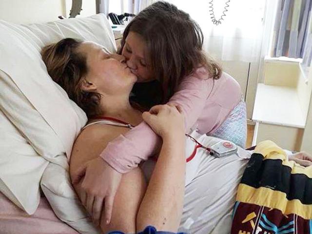 Câu chuyện xúc động sau bức hình bé gái 8 tuổi đặt nụ hôn cuối lên môi người mẹ